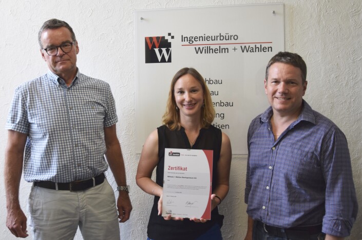 Hans Wahlen, Geschäftsführung; Nicole Häfliger, Personalverantwortliche; Christoph Schaerer, Geschäftsführung vor dem Unternehmenslogo mit dem iPunkt-Zertifikat.