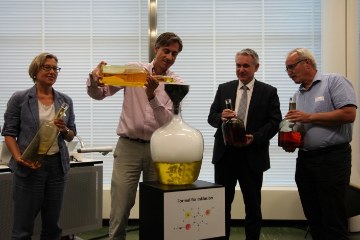 Das Foto zeigt, wie Player aus Wirtschaft und Arbeit symbolisch den CHARTA-Zaubertrank mischen